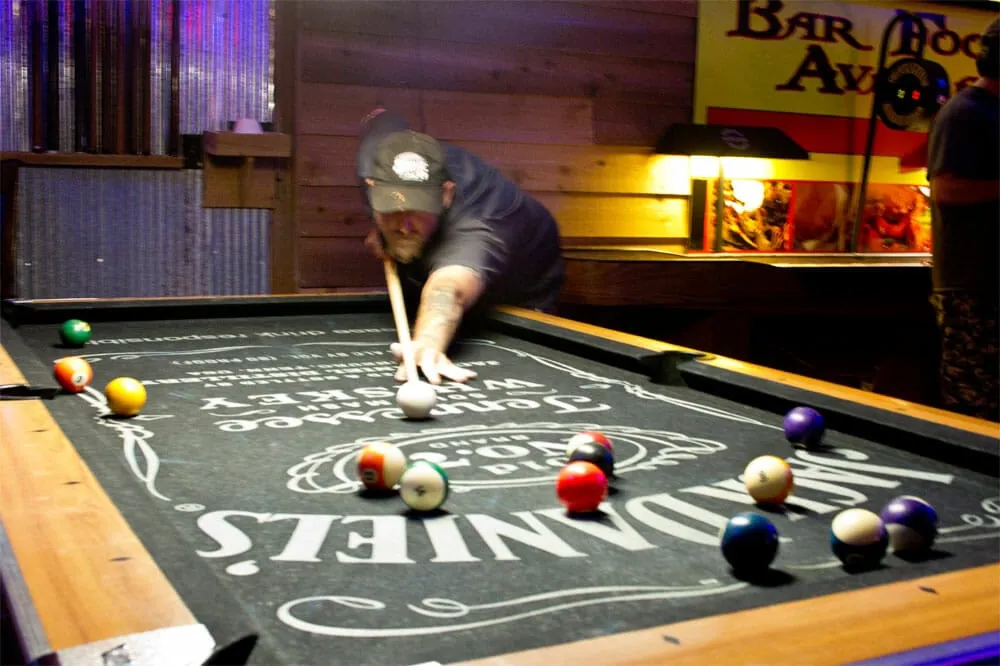 A player lining up a shot on the pool table at Club 50